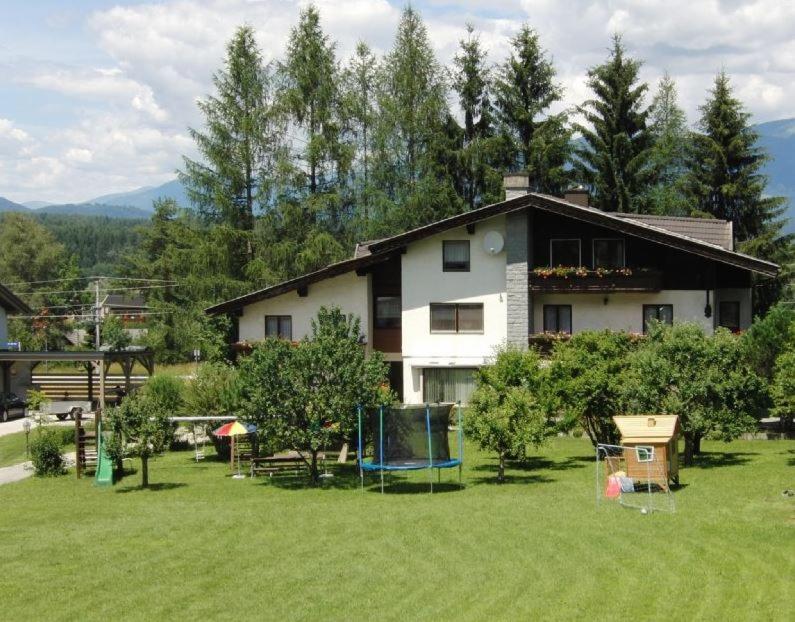 a house in the middle of a yard with trees at Frühstückspension Helmut Koffler in Faak am See