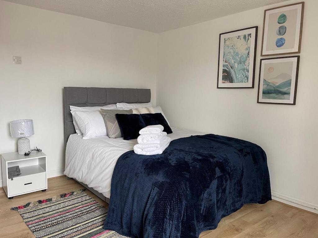 a bedroom with a bed with a blue blanket on it at Cozy two bedroom home with historic significance in Saint Neots