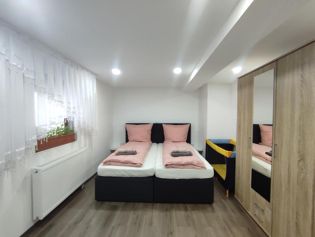 a bedroom with two beds with pink pillows at Ferienhaus Stani in Eschwege