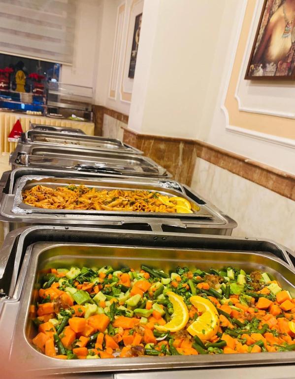 a row of trays of food in a kitchen at Tiba Rose hurghada in Hurghada