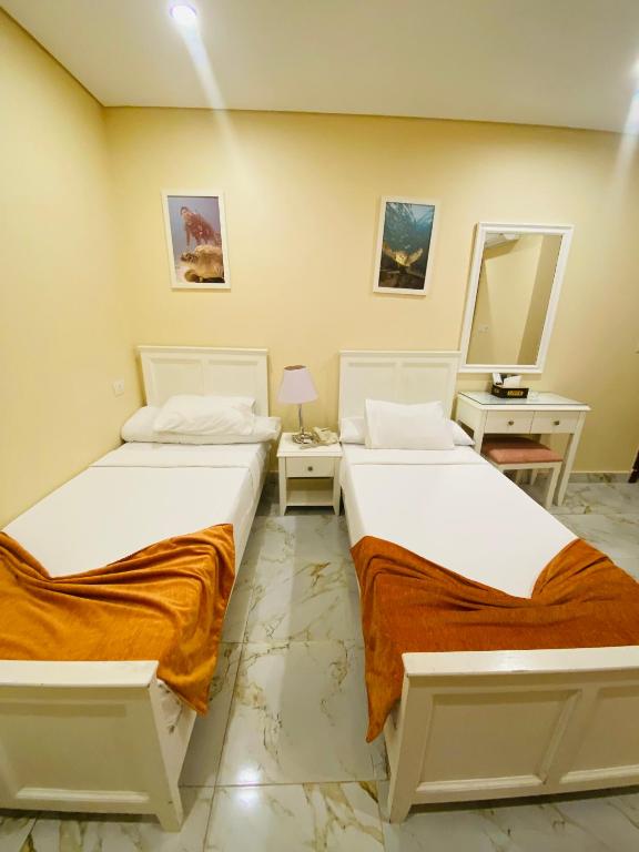 two beds sitting next to each other in a room at Tiba Rose hurghada in Hurghada