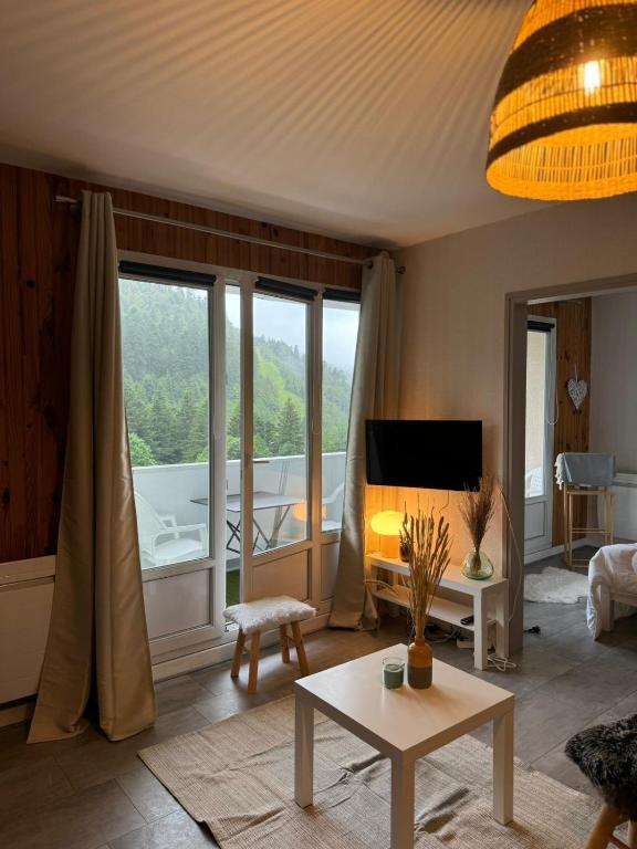 - un salon avec vue sur une baignoire dans l'établissement Le Refuge, à La Bresse