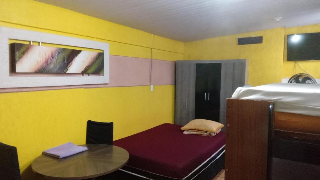 a small room with a table and a bed at Quitinete Expominas Suite Ar in Belo Horizonte