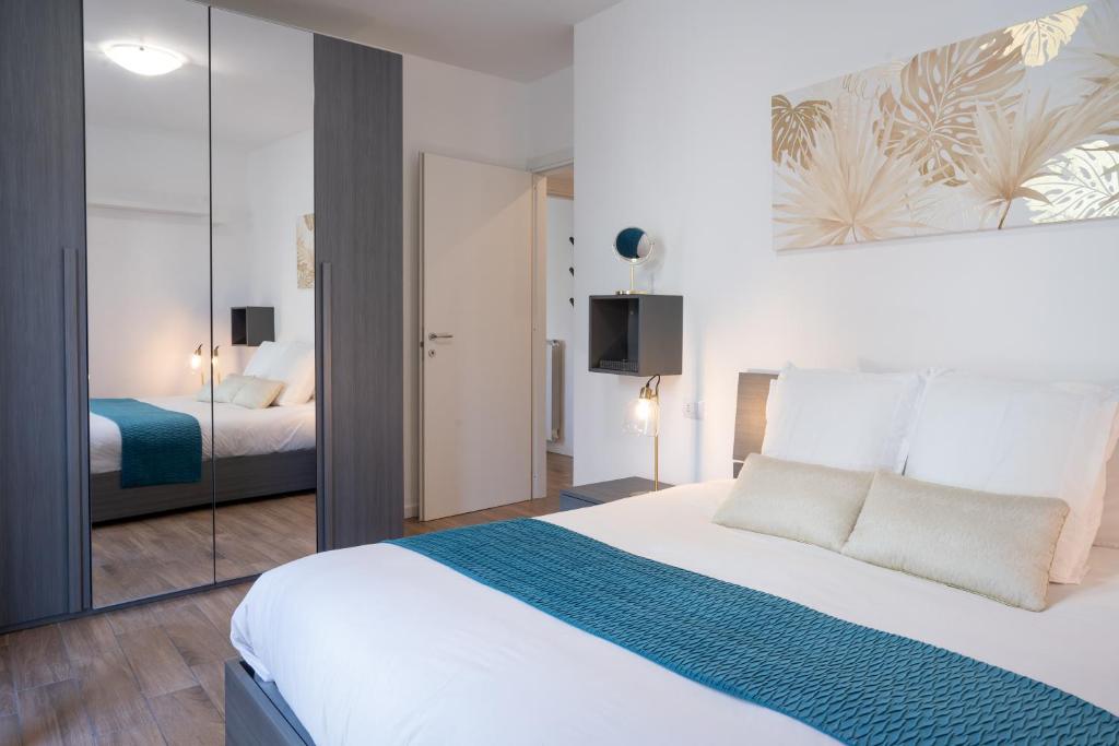 een slaapkamer met een groot wit bed en een televisie bij Lora apartment,free private parking, self check in in Como