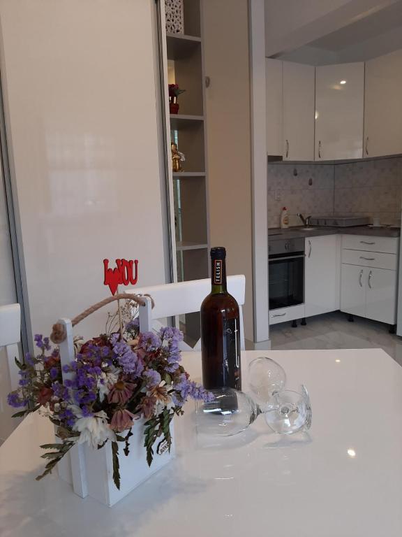a bottle of wine and a bouquet of flowers on a table at Apartmani LaVa igalo 1 in Igalo
