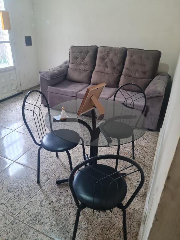 a living room with two chairs and a table and a couch at Casa de Maria in Aparecida
