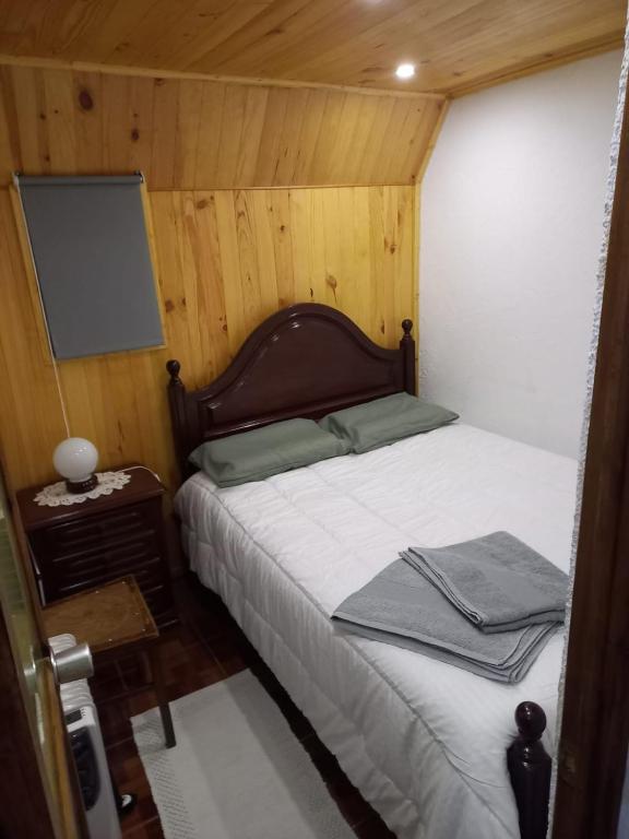 a bedroom with a bed with a tv on the wall at Casa Serrana in Penhas da Saúde