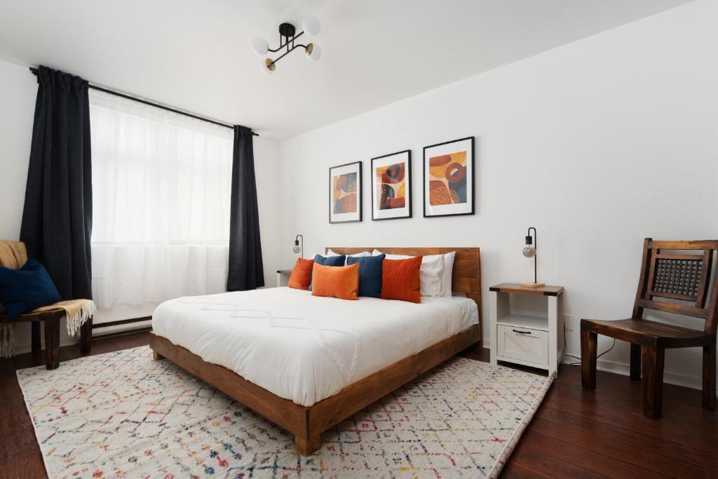 a bedroom with a bed with orange and blue pillows at Luxury Old Montreal Parking with Yard Patio 10 Guests in Montréal