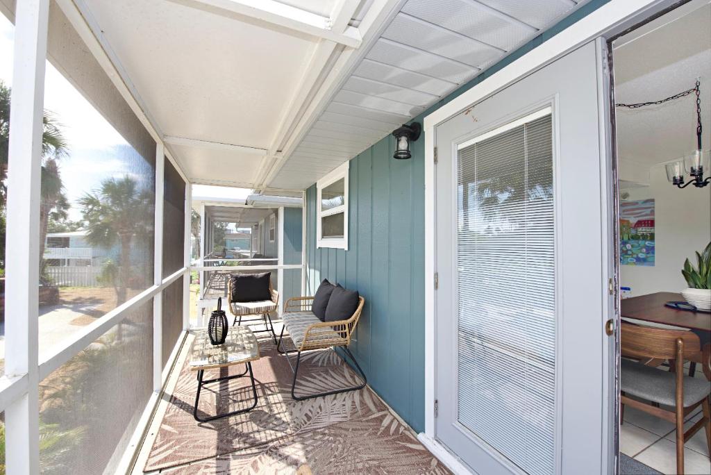 a covered porch with chairs and a table at Beach Bungalow 2 by Sun Palace Vacations in Fort Myers Beach