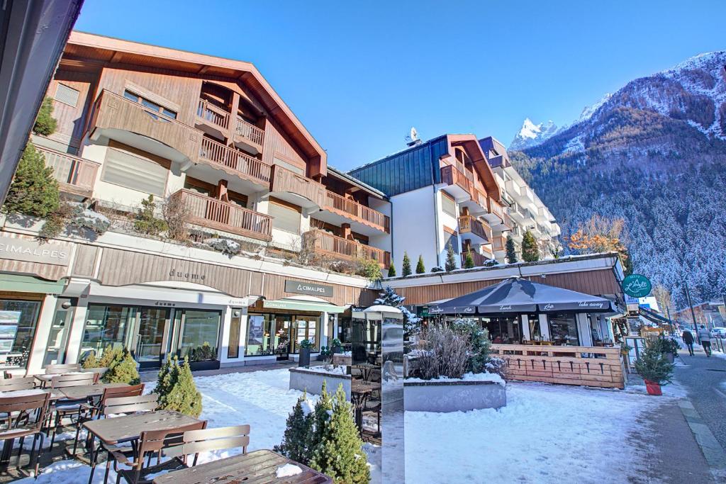un hôtel avec des tables et des chaises dans une cour dans l'établissement Duplex Aiguille Du Midi Large Terrasse - Happy Rentals, à Chamonix-Mont-Blanc