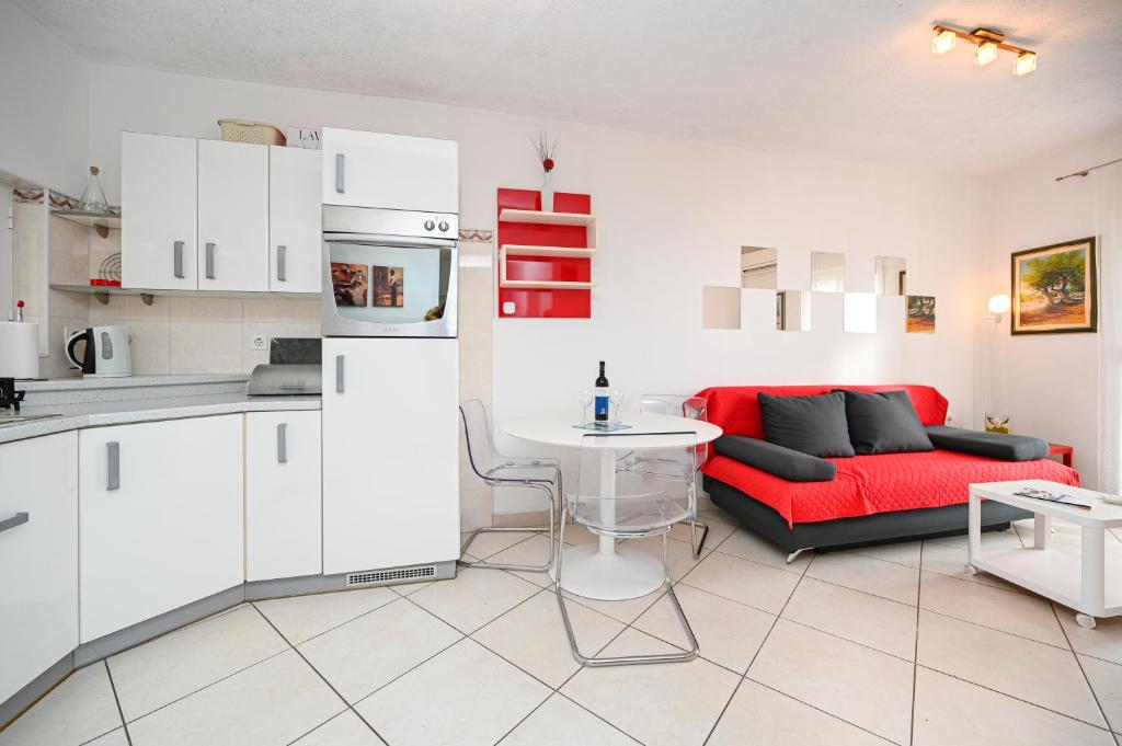 a kitchen and a living room with a red couch at Apartment Bazen in Zadar