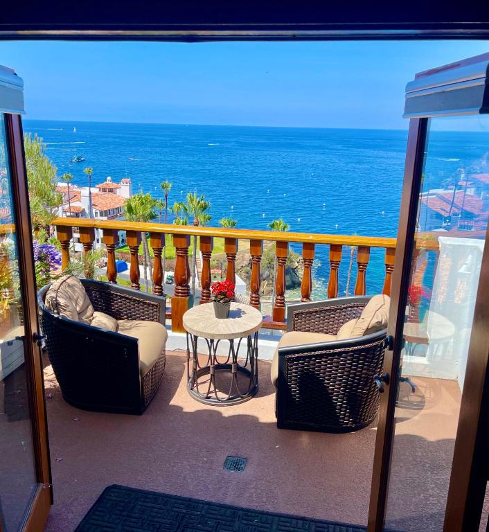 a balcony with chairs and a table and the ocean at Hillside Avalon escape w pool & panoramic views in Avalon