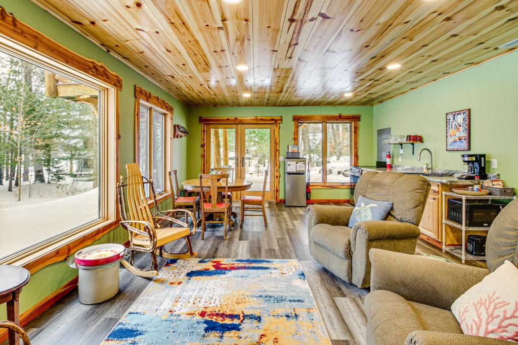 a living room with green walls and a wooden ceiling at Pokegama Lake Vacation Rental with Shared Boat Dock! in Grand Rapids