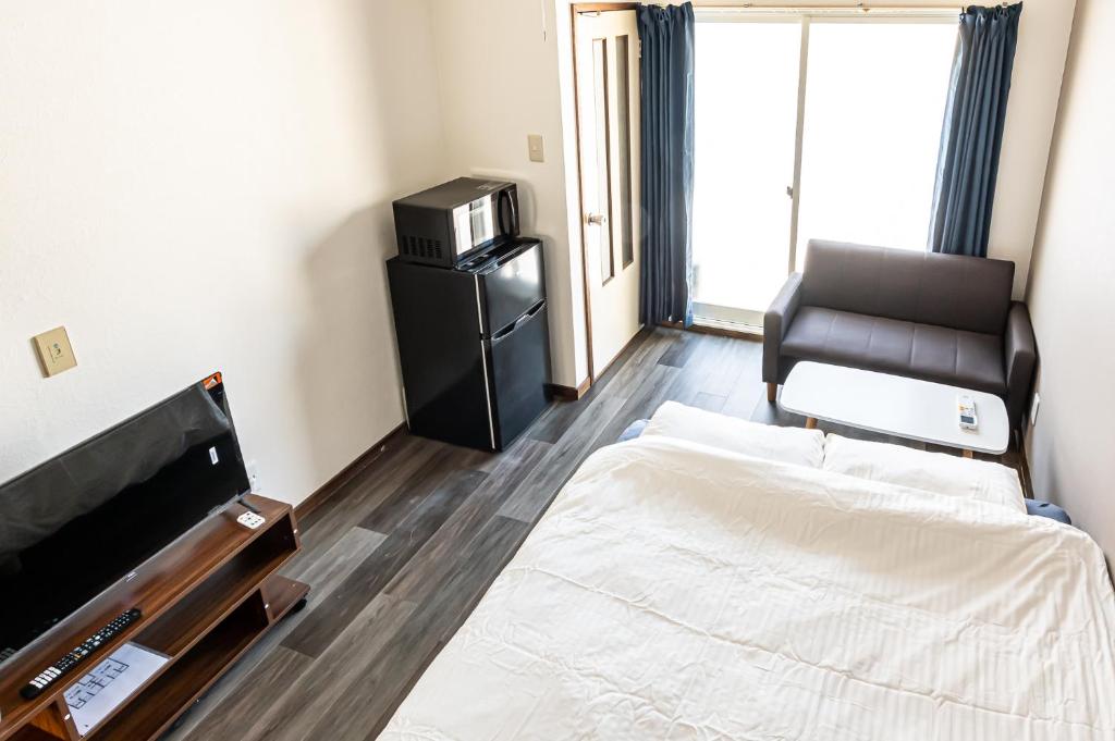 a bedroom with a bed and a chair in it at lol 3 101 in Hakodate