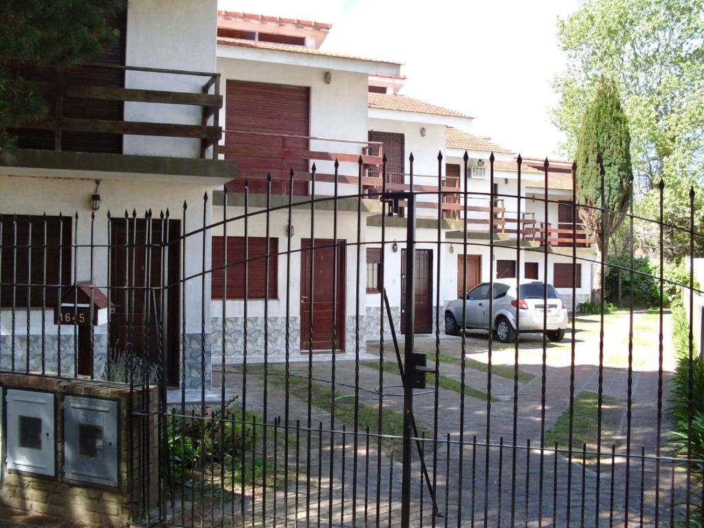 a fence with a car parked in front of a building at Duplex familiar 3 ambientes in San Bernardo