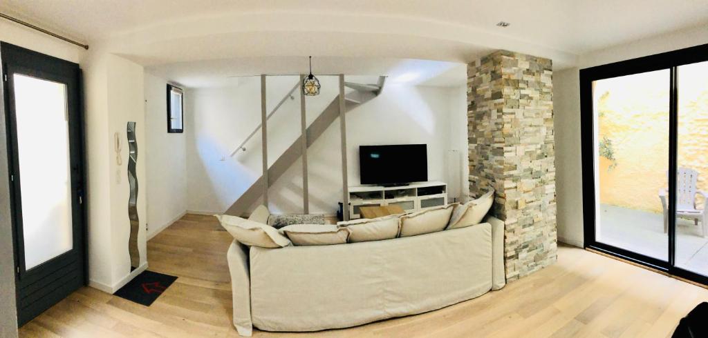 un salon avec un canapé et une télévision dans l'établissement T3 Duplex Design - Pau Centre Quartier Halles, à Pau
