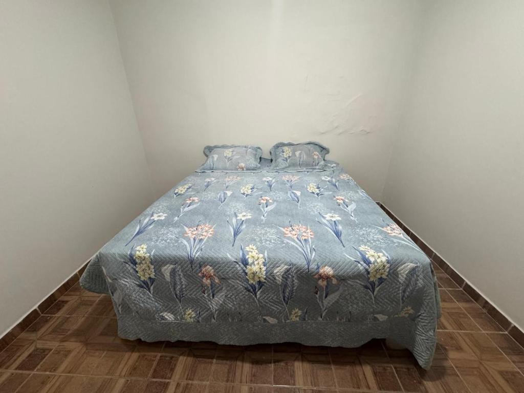 una camera da letto con un letto con un piumone blu di Casa de Temporada em Diamantina 2 a Diamantina