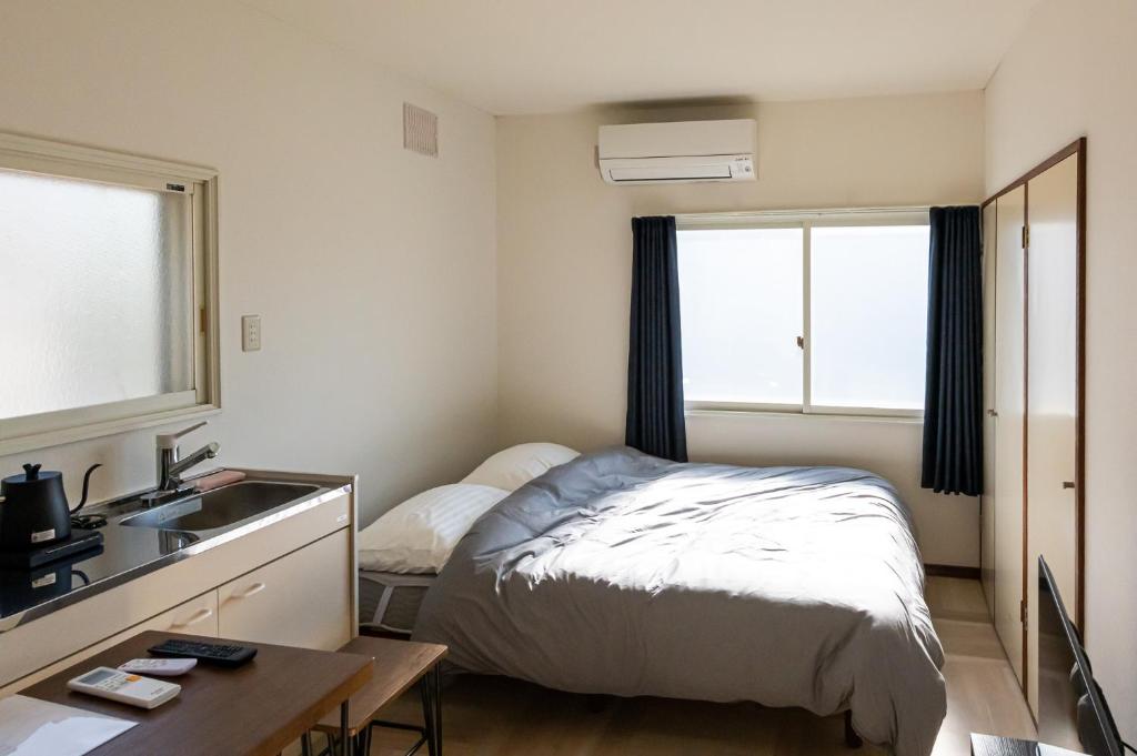 a small bedroom with a bed and a sink at lol 3 202 in Hakodate