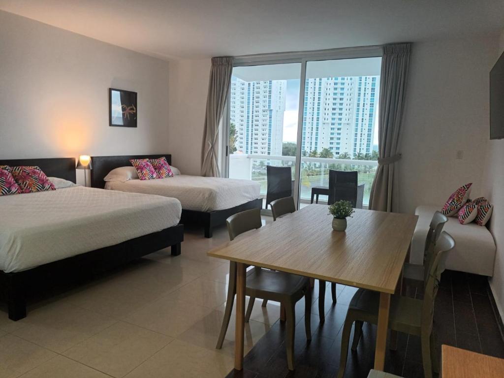 a hotel room with a bed and a table and chairs at Town Center Playa Blan in Playa Blanca
