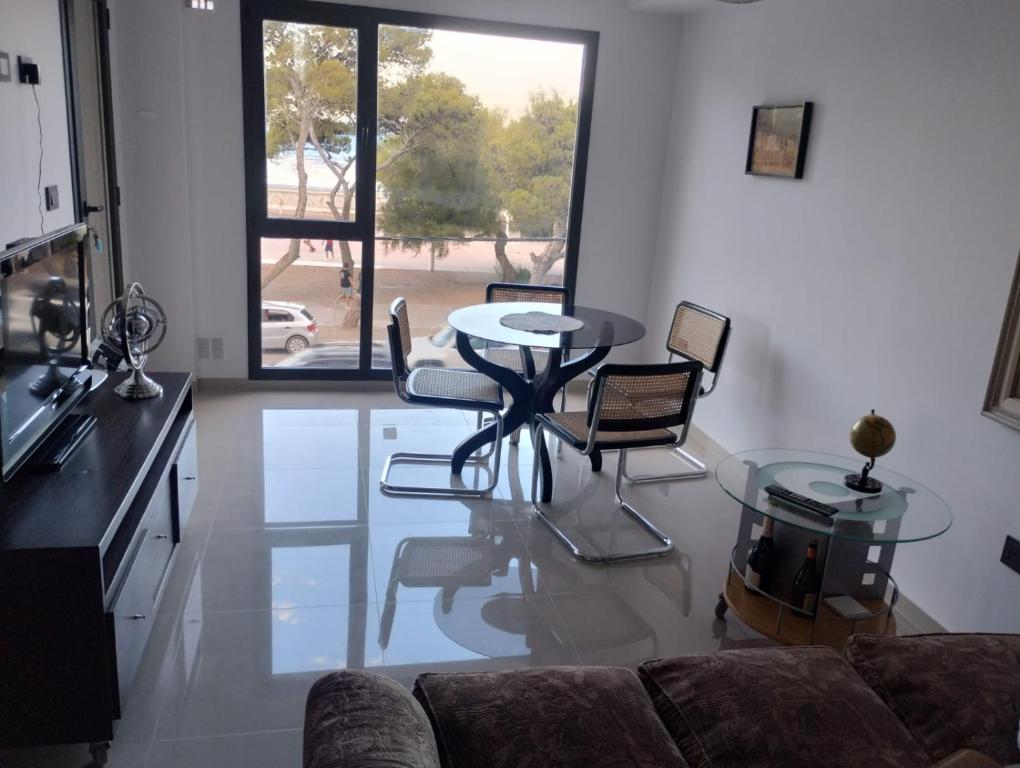 ein Wohnzimmer mit einer Couch und einem Tisch und Stühlen in der Unterkunft PLAYA - Alojamiento frente al mar in Puerto Madryn