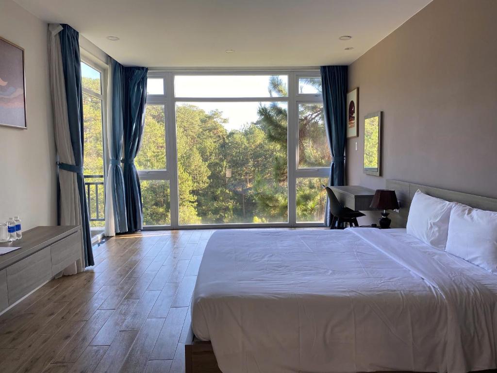 ein Schlafzimmer mit großem Bett und großem Fenster in der Unterkunft Lan Anh Villas Resort in Da Lat
