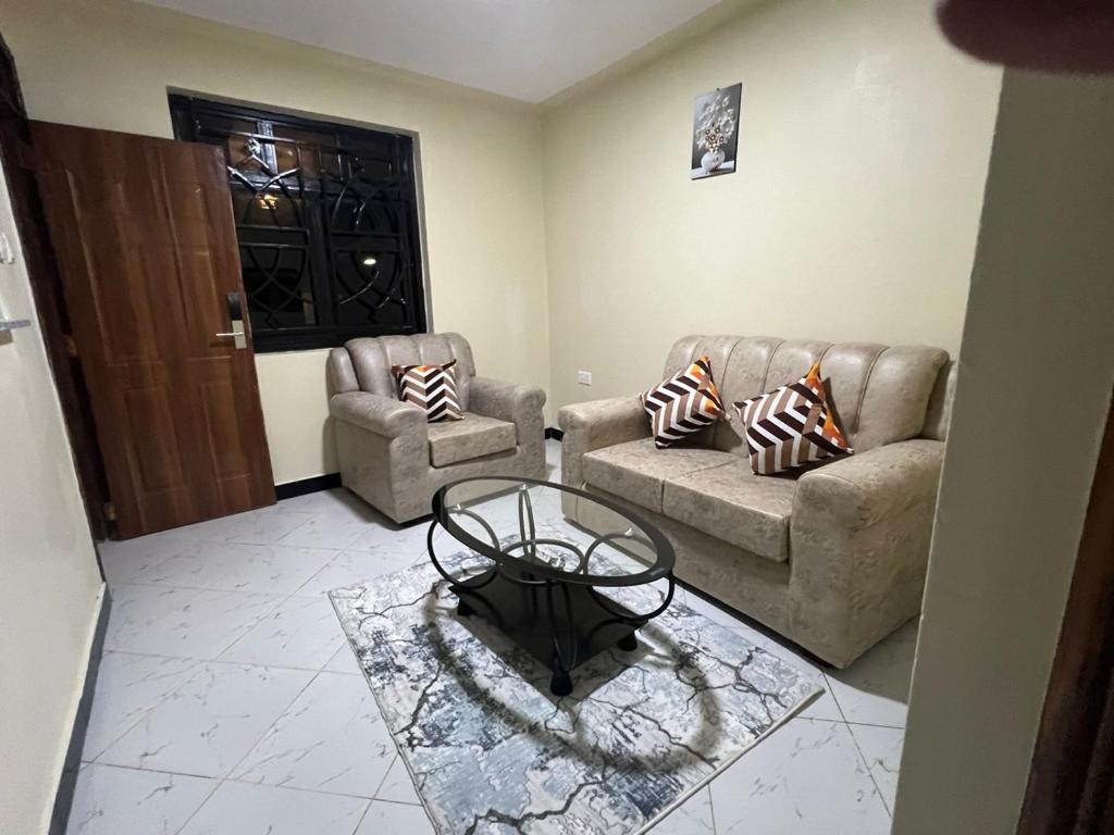 a living room with two couches and a table at Oltotoi Suites in Nairobi