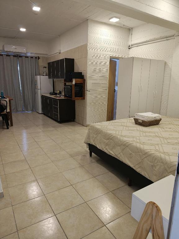 a large room with a bed and a kitchen at Departamento equipado, centrico, cochera cubierta Sarmiento265apart D17 in San Fernando del Valle de Catamarca