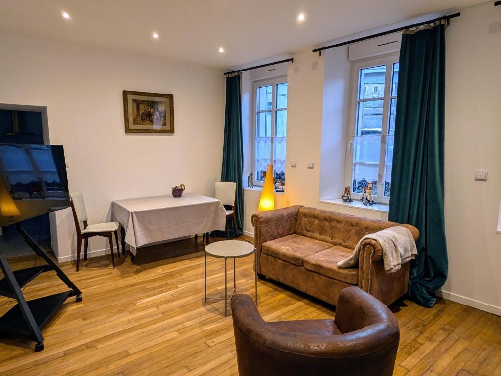 a living room with a couch and a table at Appartement romantique à Verdun avec parking privé - FR-1-585-168 in Verdun