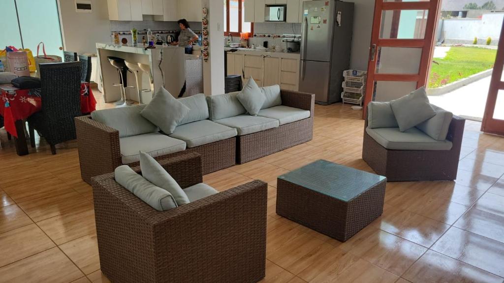 a living room with a couch and chairs and a kitchen at Villa MAS - Condominio Hacienda II in Pachacamac