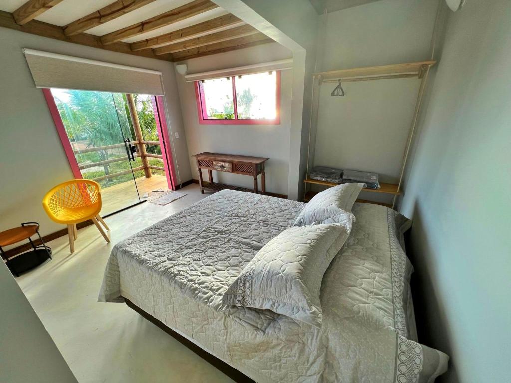 Un dormitorio con una cama y una ventana grande. en Cara,Viva Flats, en Porto Seguro