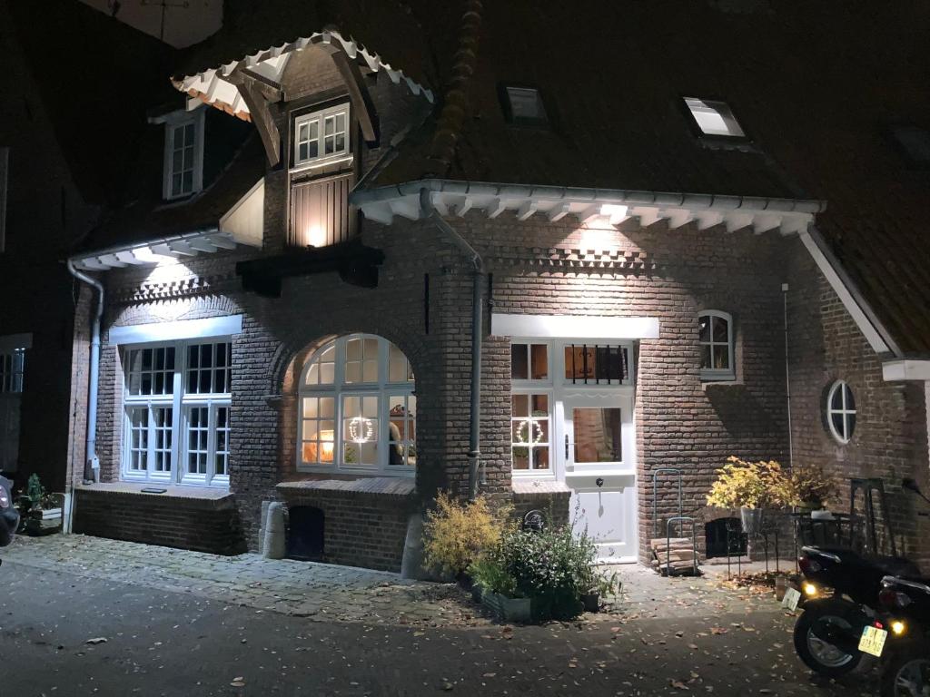 a brick house with lights on it at night at Le Pigeonnier, maison d'hôtes et Spa in Croix