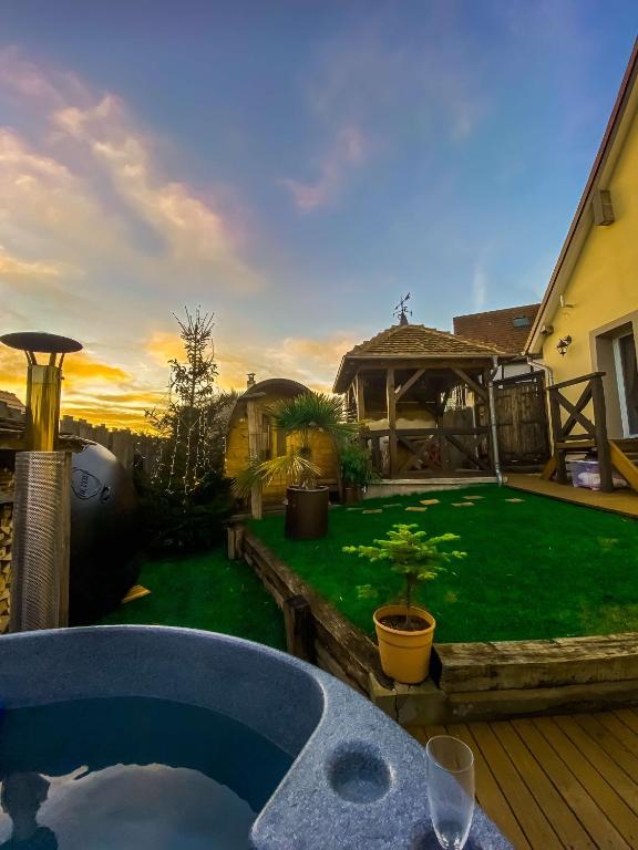 une cour avec un bain à remous et une pelouse verte dans l'établissement Gîte Bien-être, Sauna, Bain nordique à Soucht (57), à Soucht