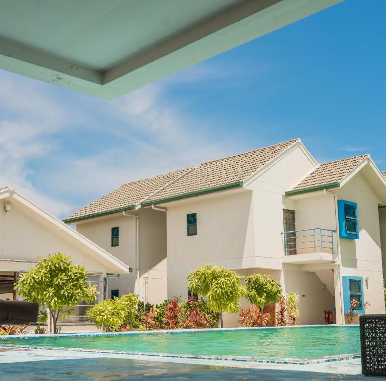 dom z basenem przed nim w obiekcie Long Beach Laamu Hotel w mieście Gan