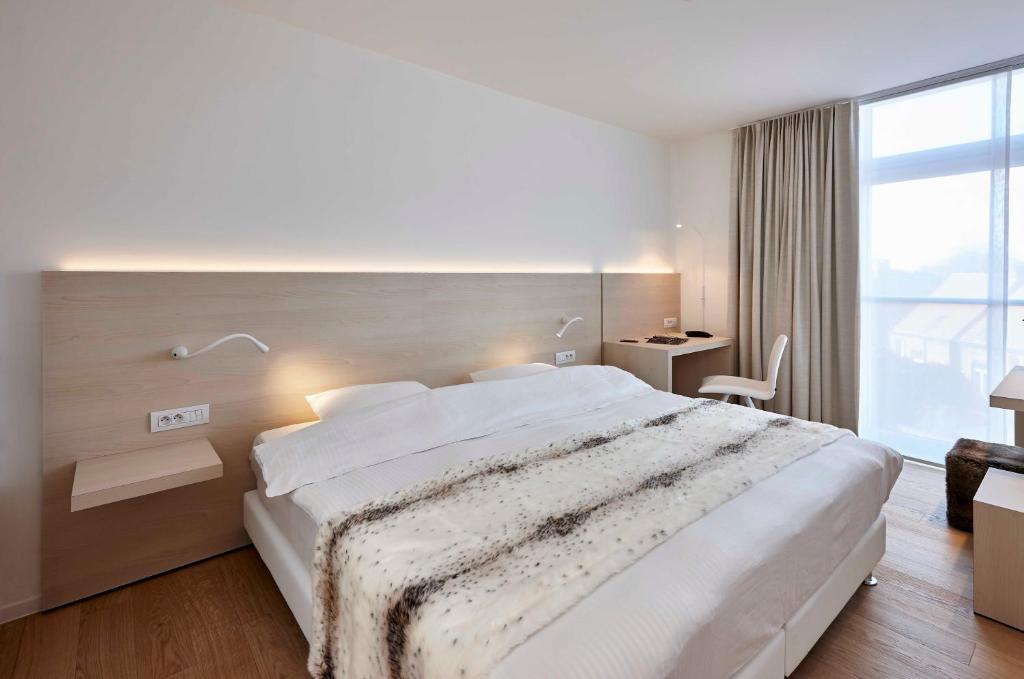 een slaapkamer met een groot bed en een groot raam bij Parkhotel Izegem in Izegem