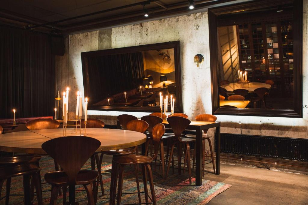 a restaurant with tables and chairs and a fireplace at Story Hotel Riddargatan, part of JdV by Hyatt in Stockholm