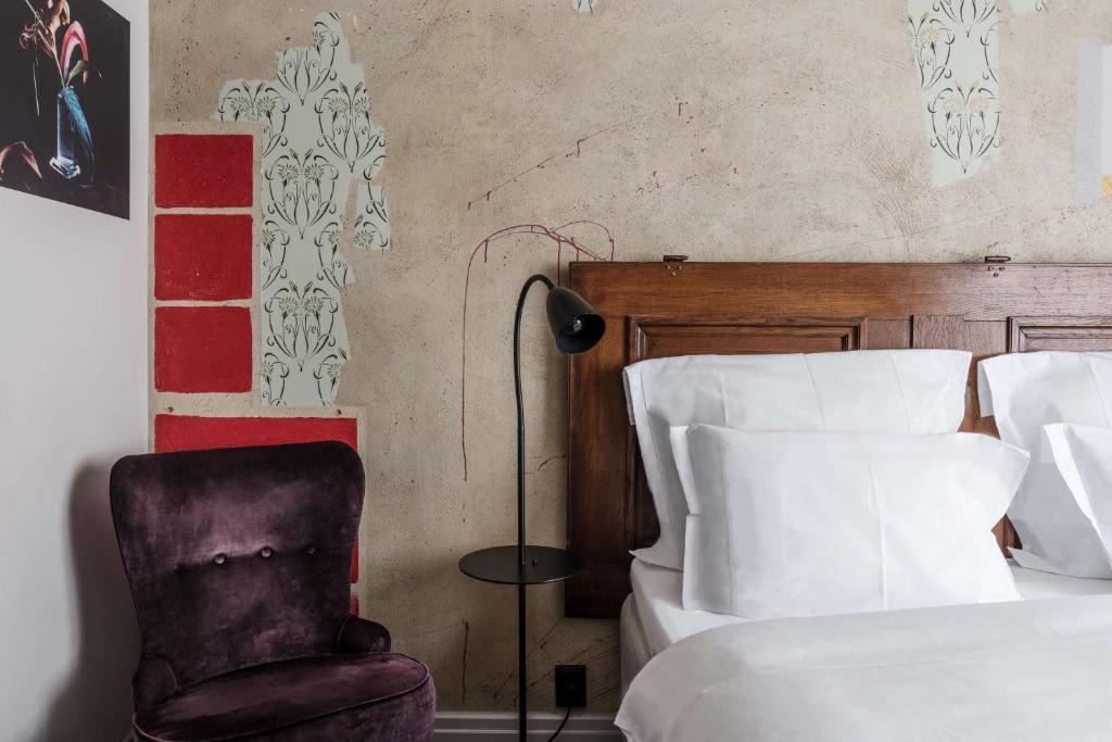 a bedroom with a chair next to a bed at Story Hotel Riddargatan, part of JdV by Hyatt in Stockholm