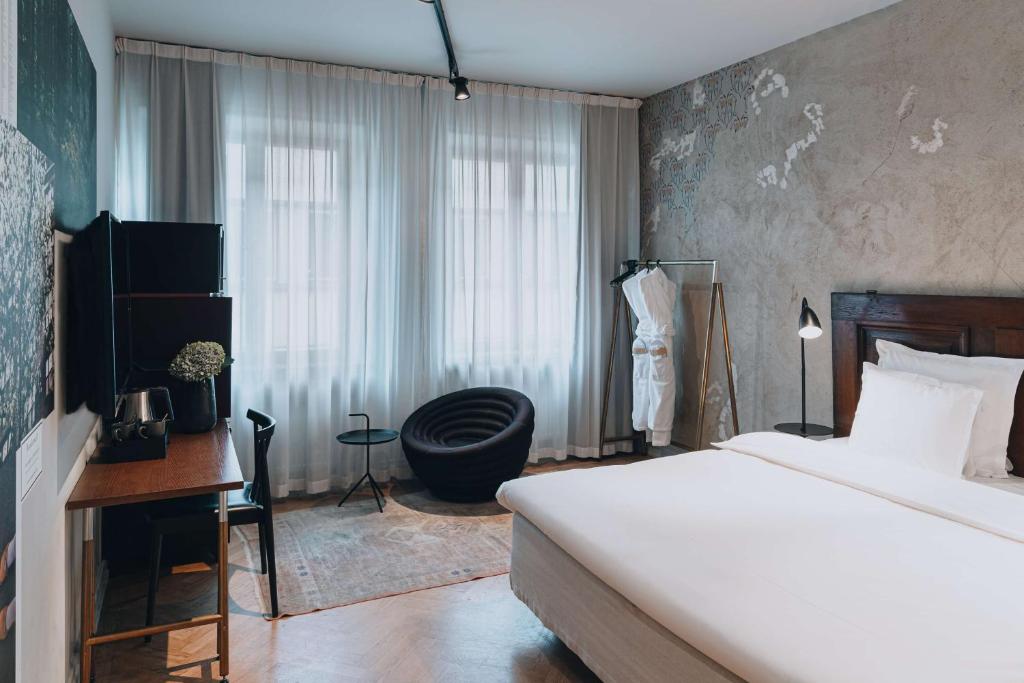 a bedroom with a bed and a chair and a window at Story Hotel Riddargatan, part of JdV by Hyatt in Stockholm