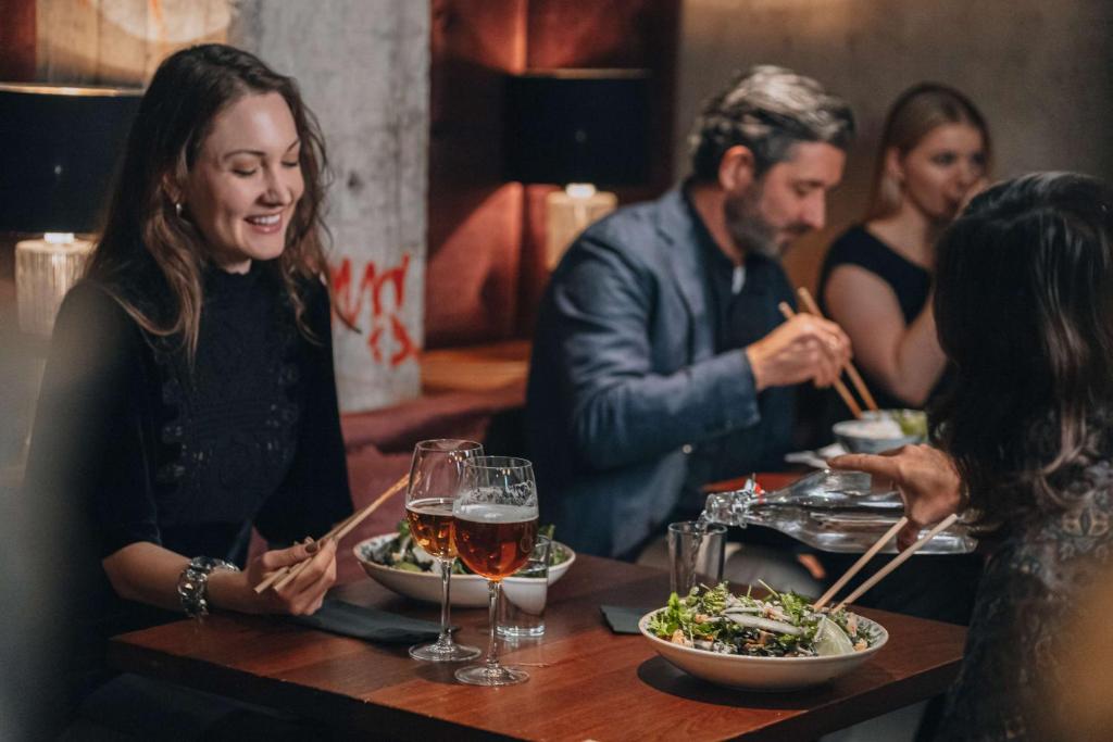 a group of people sitting around a table eating food at Story Hotel Riddargatan, part of JdV by Hyatt in Stockholm