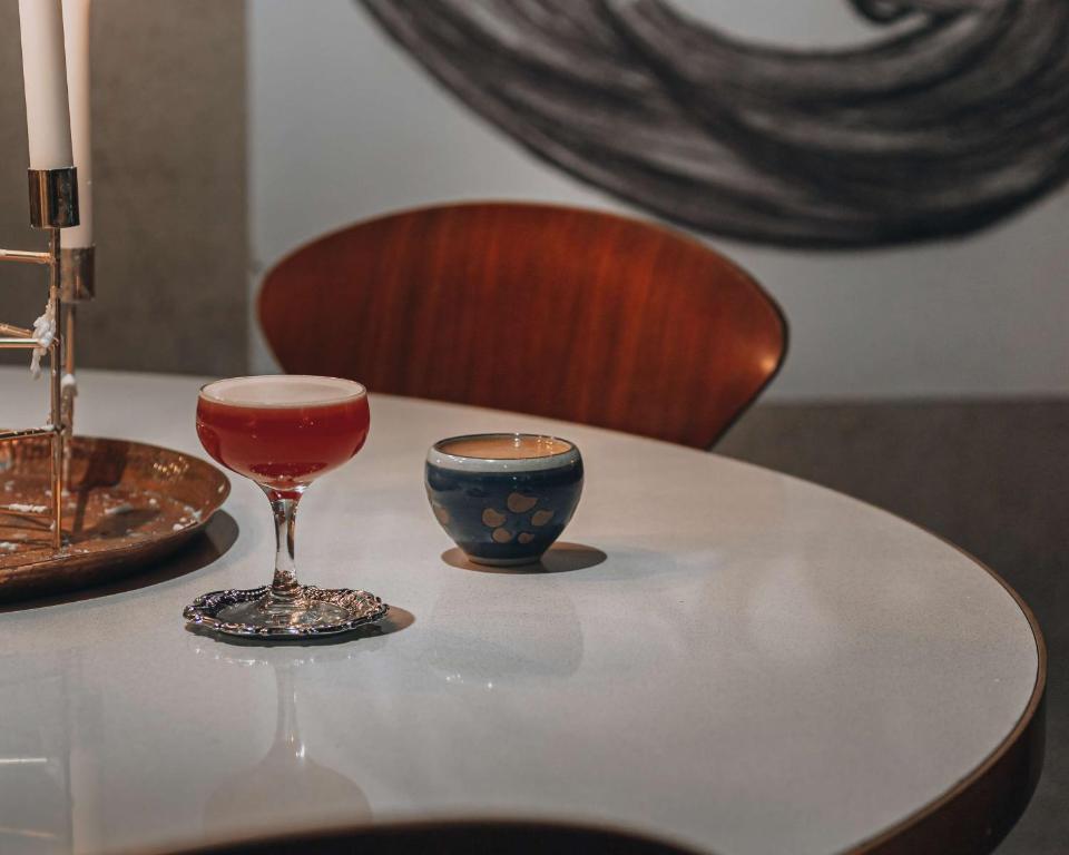 a glass of wine and a cup on a table at Story Hotel Riddargatan, part of JdV by Hyatt in Stockholm