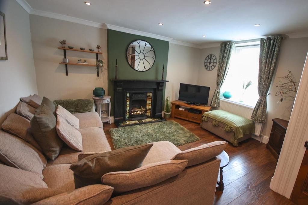 un soggiorno con divano e camino di Mill Cottage a Clitheroe