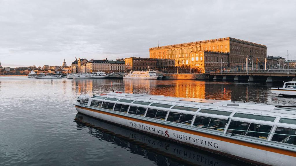 a boat is docked on a river in a city at Story Hotel Riddargatan, part of JdV by Hyatt in Stockholm