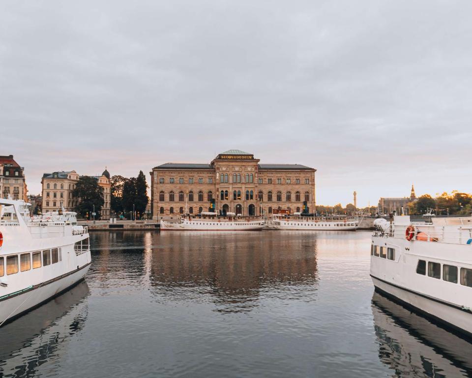 two boats in the water in front of a building at Story Hotel Riddargatan, part of JdV by Hyatt in Stockholm