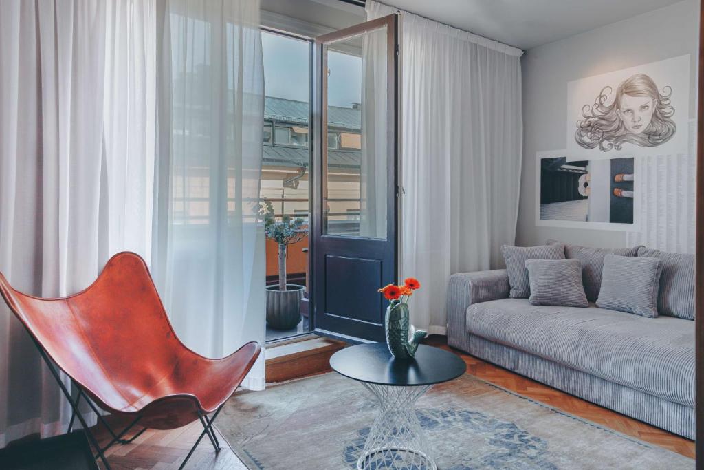 a living room with a couch and a table and a chair at Story Hotel Riddargatan, part of JdV by Hyatt in Stockholm