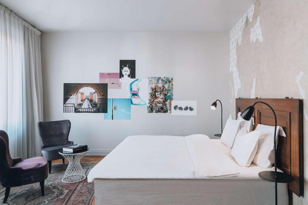 a bedroom with a white bed and a chair at Story Hotel Riddargatan, part of JdV by Hyatt in Stockholm