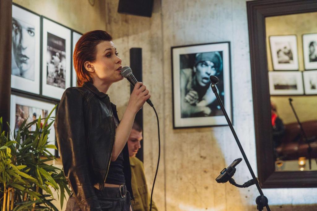 a woman standing in front of a microphone at Story Hotel Riddargatan, part of JdV by Hyatt in Stockholm