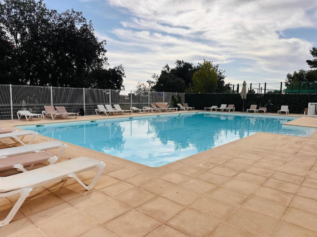 une grande piscine avec des chaises longues dans l'établissement Maison avec jacuzzi privatif dans résidence, à La Gaude