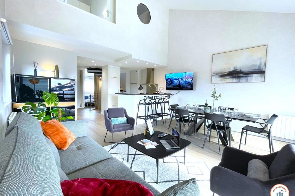 un salon avec un canapé et une salle à manger dans l'établissement Le Majestic - Vue Mer - Plage - Casino, à Deauville