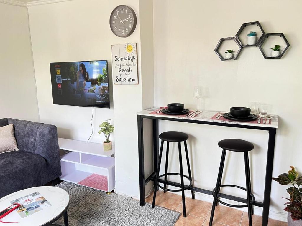 a living room with a table and two stools at Pequeno Cielo Staycation in Nairobi