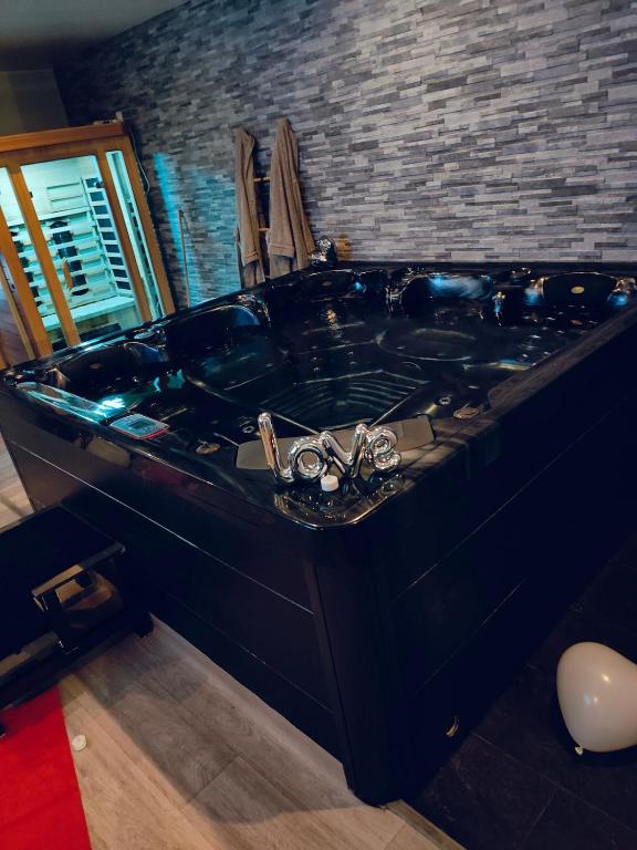 a large black bath tub in a room at At dream, logement privatif in Bergues