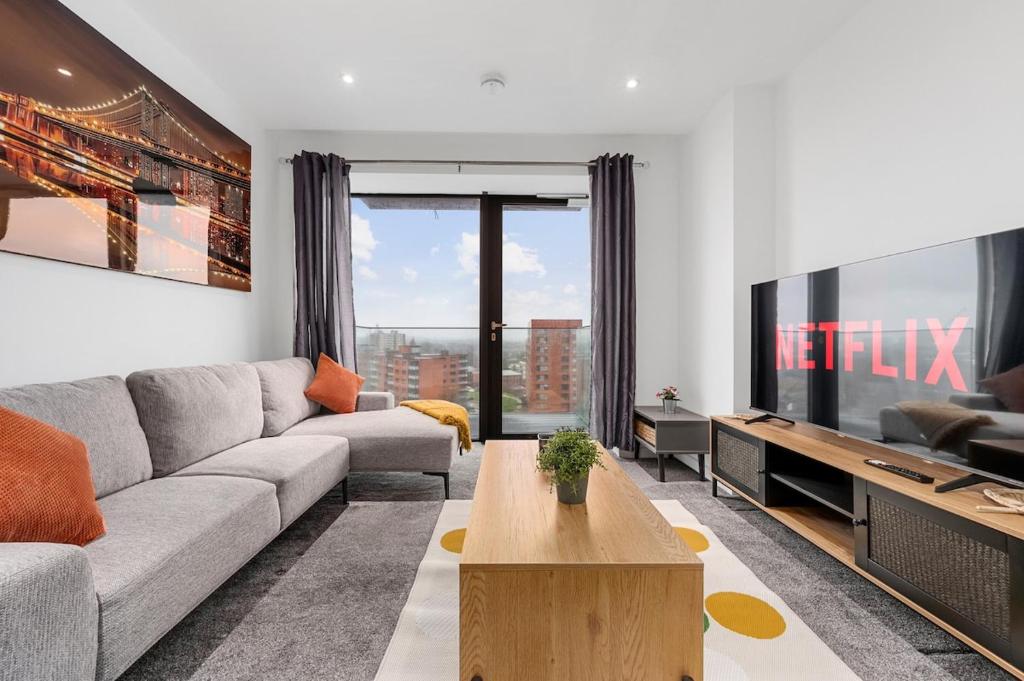 a living room with a couch and a tv at Modern Luxurious Central Apartment in Manchester